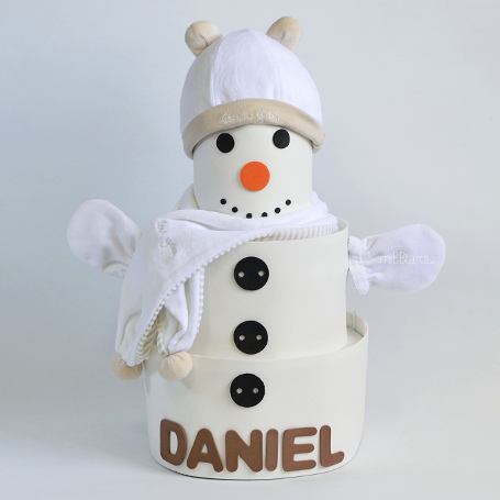 Tarta de pañales formada por un conjunto de gorro manoplas y bufanda y prácticos pañales para el recién nacido